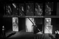 Black and white image of 3 performers on stage in an emotional scene