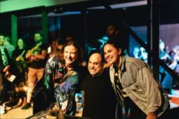 Two female concert goers posing for a photo with performer Brenden Borellini