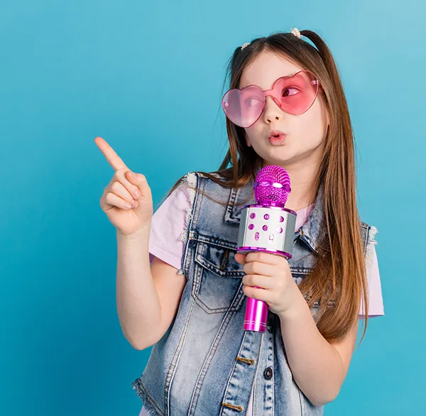 a young kid with sunglasses, confidently singing into a toy microphone